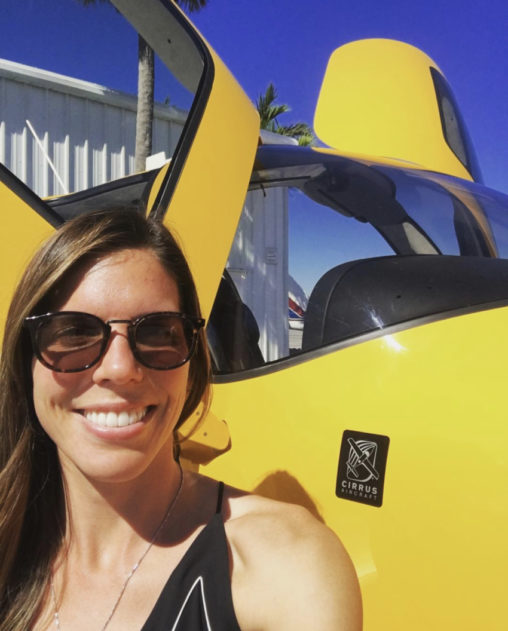 Pilot Amy Voss standing in front of a bright yellow airplane.