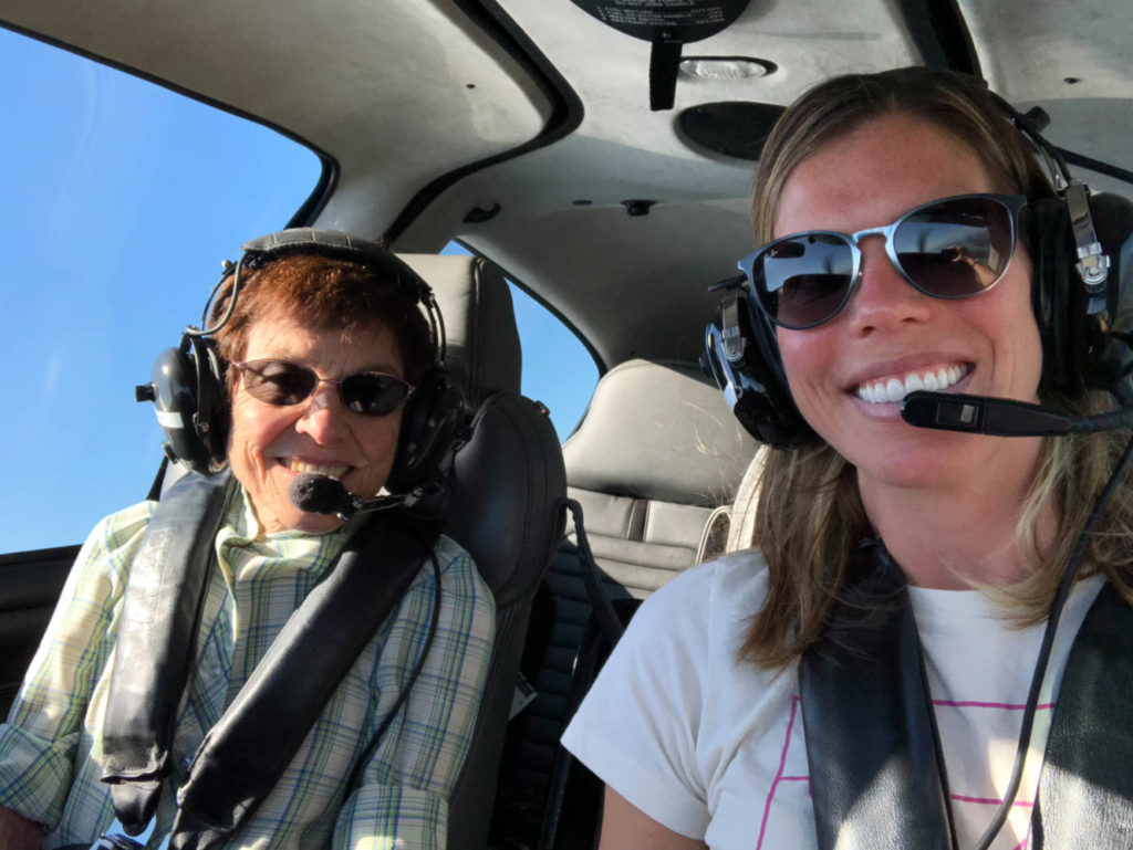 Pilot Amy Voss sitting in an airplane with her mother, both wearing headsets.