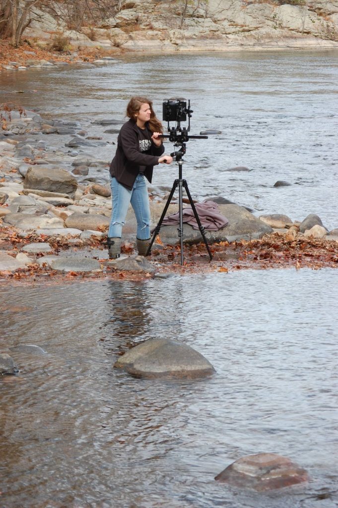 Haley Hensley Photography taking a picture in the water of a river.