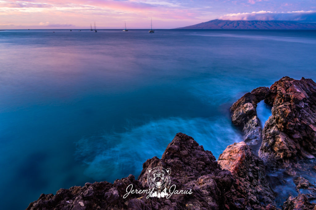Photo of water, rocks, and a bridge in the distance, taken by Jeremy Janus Photography