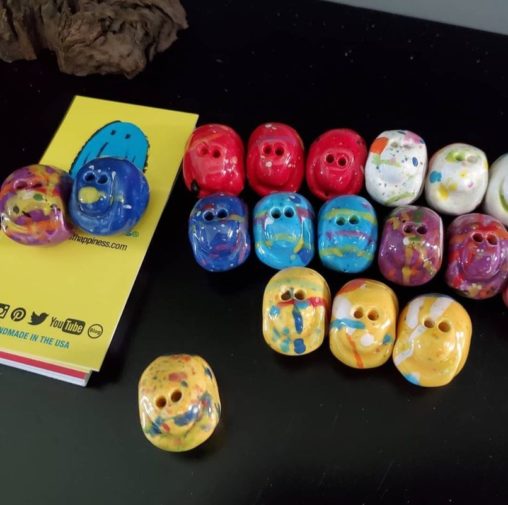 Different colored Seeds of Happiness sitting on a black countertop. Created by Mark Borella, the "Seeds of Happiness Guy".