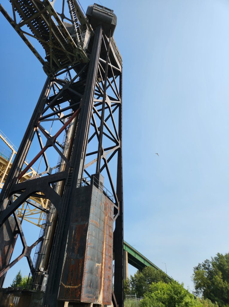 A large metal structure against the blue sky. The lift for the lift span of the International Railroad Bridge.