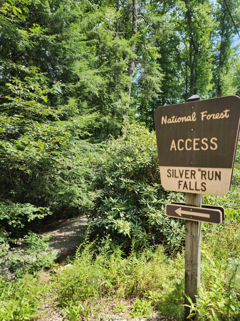 A sign that reads "National Forest Access Silver Run Falls" with an arrow pointing to the left.